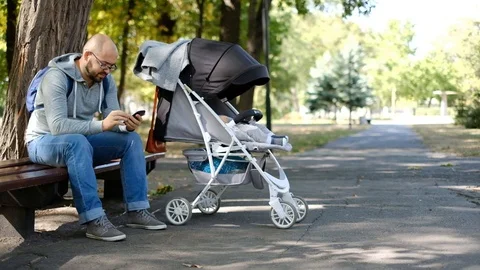 Man walks with a stroller in the park. Stock Footage 118690630