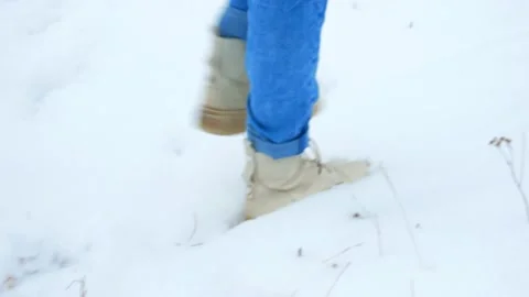 A man walks on a thin layer of snow. Feet walking on the snow close-up. Video stock 221895377