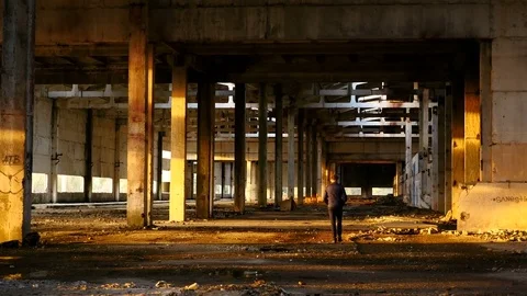 Man walks in threw a hangar at sunset yellow autumn Stock Footage 83095668