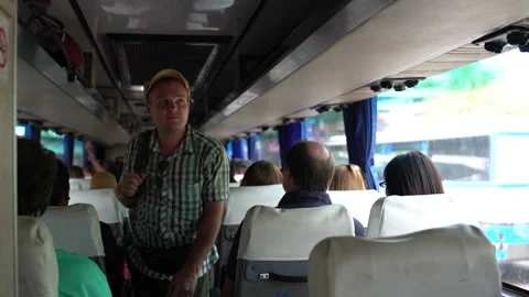 A man walks through the cabin of the bus, removes the bag on the luggage rack Stock Footage 91707352