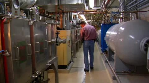 Man walks through complex machine room 스톡 동영상 21530406