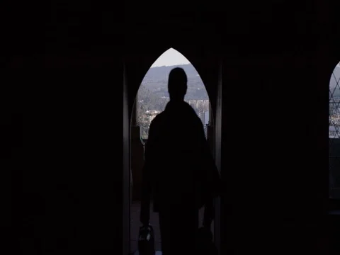 Man Walks Through Dark Corridor With View of City Stock Footage 78011741