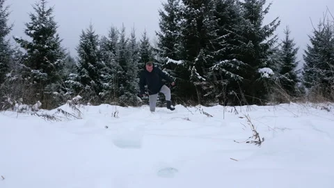 A man walks through deep snow in a winter forest 스톡 동영상 145146529