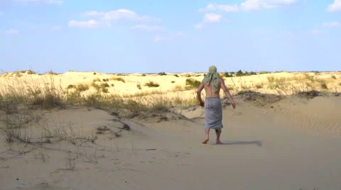 A man walks through the desert Vídeo Stock 67335154