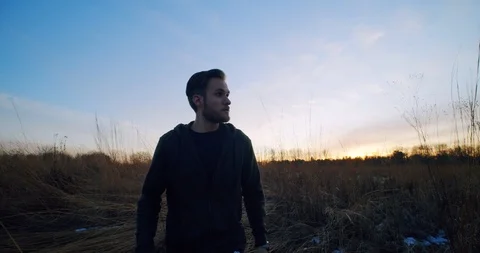Man Walks Through Field During Sunset Stock Footage 122221642
