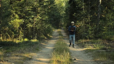 A man walks through the forest with a laptop and looking map He chooses the Video stock 65016249