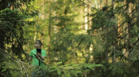 A man walks through the forest with a tablet PC and looking at the navigation Stock Footage 65022377
