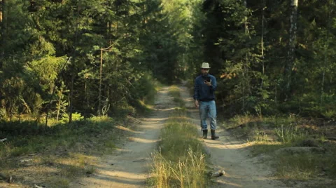 A man walks through the forest with a tablet PC and looking at the navigation Stock Footage 65022949
