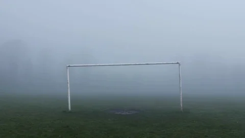 Man walks through goal posts on misty atmospheric sports field medium shot 스톡 동영상 78008508