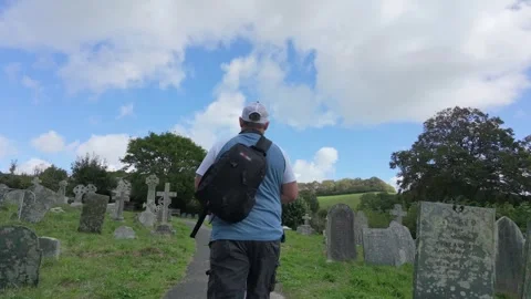Man walks through historic graveyard in Cornwall Stock Footage 345006056
