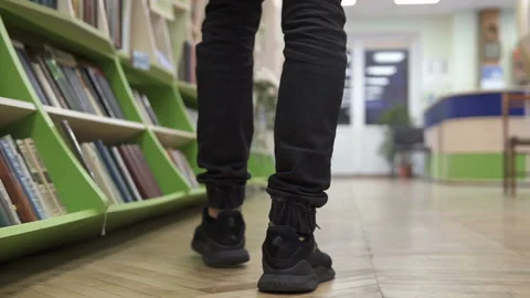 A man walks through the library, looking for a suitable book Vídeo Stock 120022019