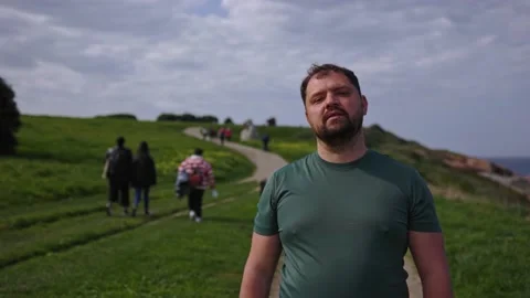 A man walks through a park along the ocean. Stock Footage 179622151
