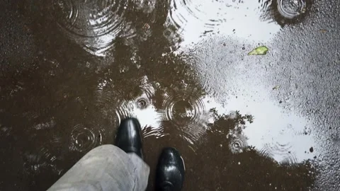 A man walks through puddles in rubber boots Stock Footage 137190663