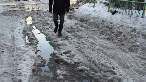 A man walks through the slush. It is difficult to pass. In the northern city Stock Footage 88737124