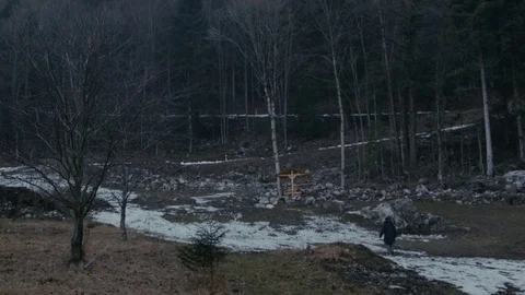A man walks through the snow in a forest in the mountains Stock Footage 77828466
