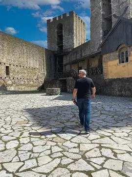 A man walks through the stone-paved courtyard of an ancient fortress Foto stock