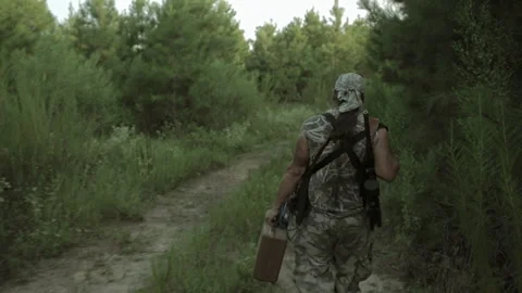 Man walks through woods with backpack and mask during evening hours Stock Footage 327959792