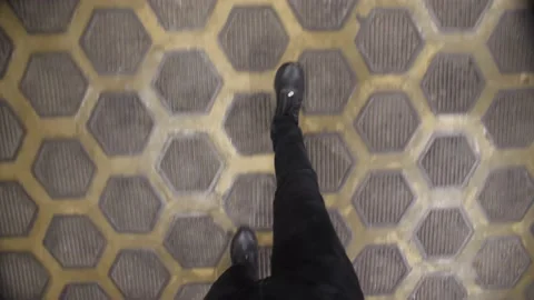 A Man Walks on a Tile. Legs in the Frame. View from above. He enters the Hall. Stock Footage 174731643