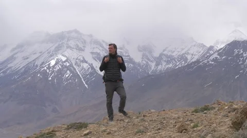 Man walks on top of a mountain background of Himalayas snowy peaks Stock Footage 141793830
