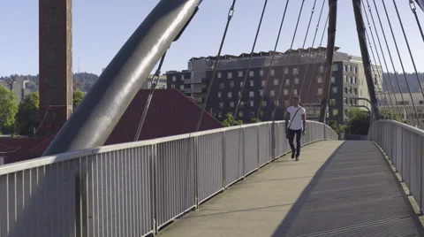 Man Walks Toward Camera On Pedestrian Bridge On A Sunny Day In The City Stock Footage