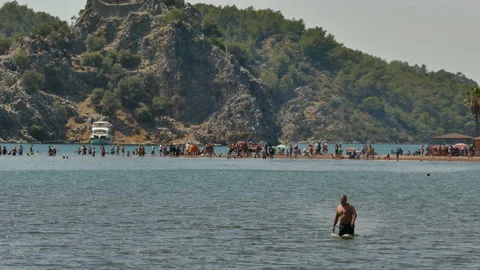 A man walks towards the camera on the famous beach of Marmaris, Kızkumu. 库存影片 211844070