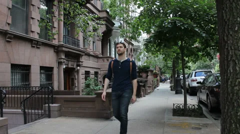 Man walks towards camera in New York City residential neighborhood 스톡 동영상 25681910