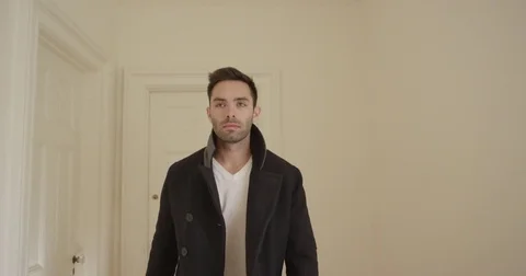 A man walks towards camera in a nice house wearing a peacoat Stock Footage 73252205