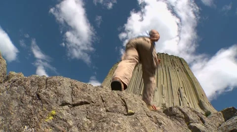 Man walks towards Devil's Tower National Monument Stock Footage 8537718