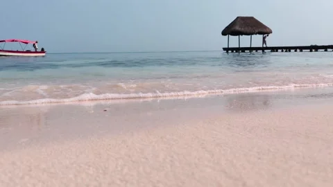A man walks under a straw hut of a pier on a paradisiac island with Vídeo Stock 149289672