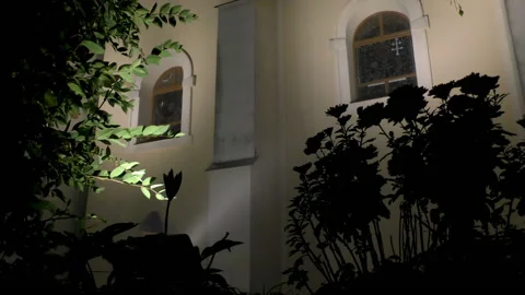 A man walks under the windows of a Catholic church on a foggy night Vídeo Stock 221829884