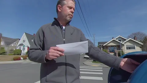 Man walks up to a USPS mailbox to mail a letter Stock Footage 150828114