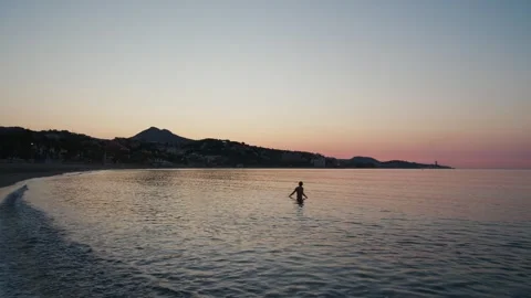 Man Walks Into Vast Ocean at Magic Hour, Embracing Solitude and Serenity Ag.. Stock Footage 344688673