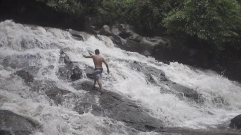Man Walks up Waterfall in Bali Stock Footage 106152648