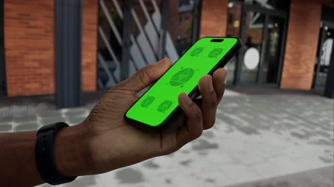 A man walks while holding a phone with a green screen Stock Footage 292910477