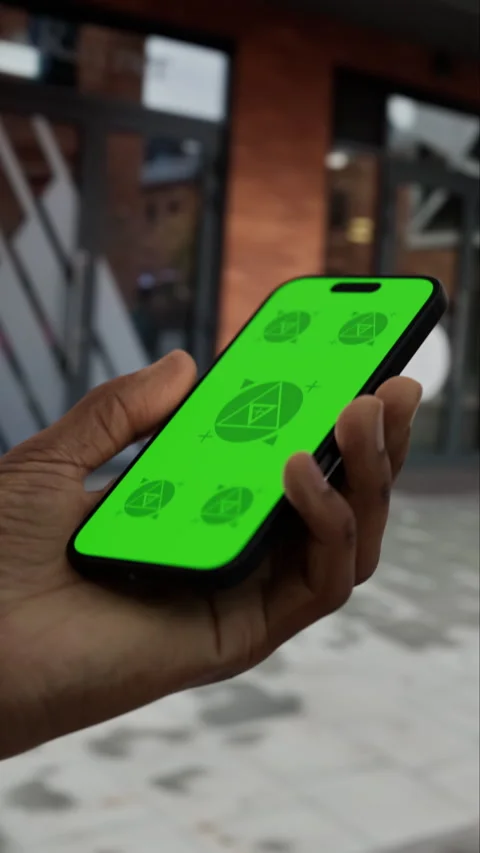 A man walks while holding a phone with a green screen Stock Footage 292910480