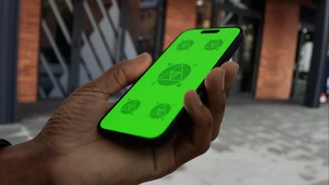 A man walks while holding a phone with a green screen Stock Footage 292910482