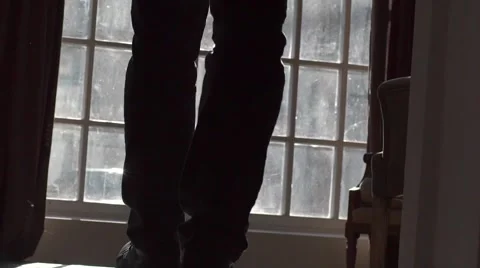 A man walks to the window and drops the book Stock Footage 61523826