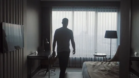 A man walks up to the window and opens the curtains Stock Footage 124023902