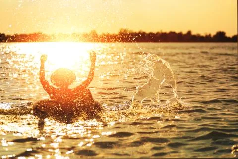 A man ware hat and he is on swim tube in the water. He is hands up to make wa Foto stock
