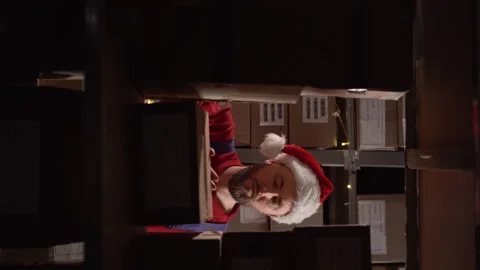 Man warehouse worker checking products or parcel goods between shelves in Stock Footage 248370147