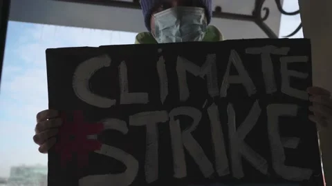 A man in warm clothes and with ice on his hat holding a "Climate Strike" Stock Footage 148841797