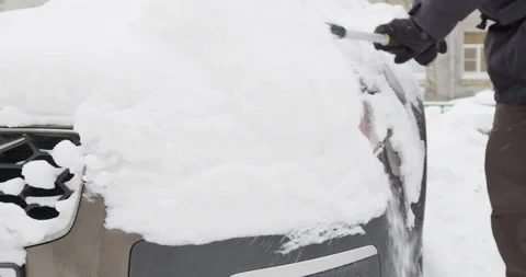 Man in warm clothes cleans his car from snow 스톡 동영상 169585478