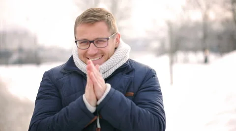 Man warm up hands and smiling to the camera in the park Vídeos de archivo 46875836