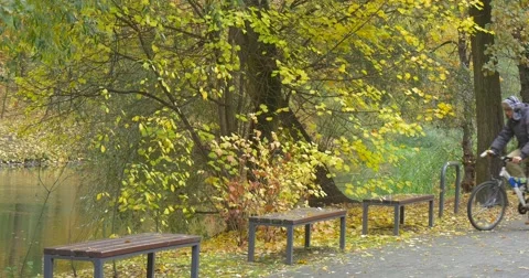 Man in Warm Hat Ushanka Hat Warm Jacket Man with Backpack is Riding the Bicycle Stock Footage 56946461