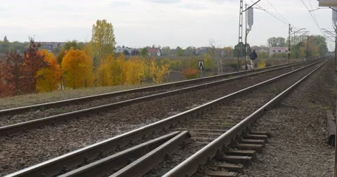Man in Warm Ushanka Hat Jacket And Earphones is Walking by Railroad Railway by Stock Footage 56961559
