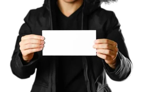 A man in a warm winter jacket holding a white leaflet. Blank paper. Close up. Fotos Stock