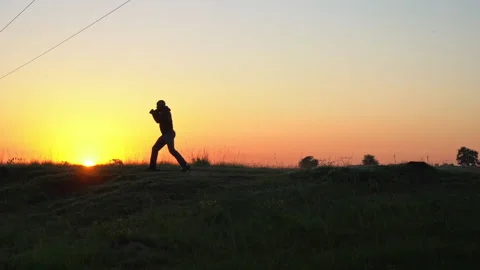 Man warming up and boxing on a hill at dawn Stock Footage 132454076