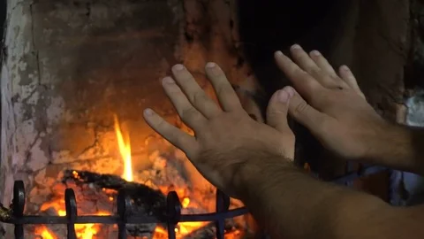 Man Warming Hands by Fireplace Video stock 77204196