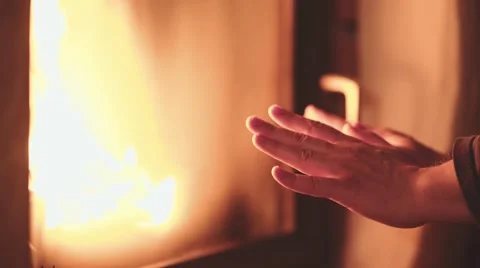 Man Warming Hands in front of Burning Fireplace, 4K Close Up. Vidéo 66730571