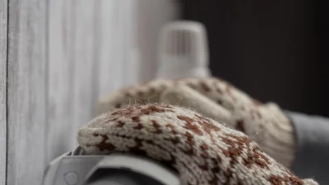A man warming hands with heating radiator at home, close-up. Hands in winte.. Video stock 288011989
